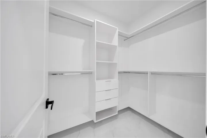 Walk in closet with light marble finish floors