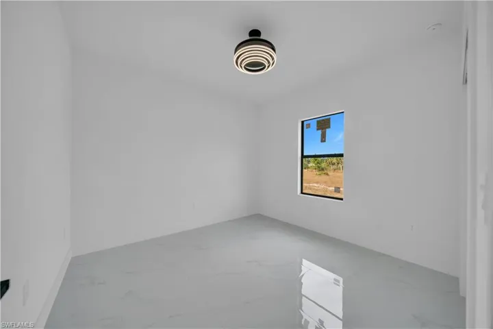 Spare room featuring light marble finish floors