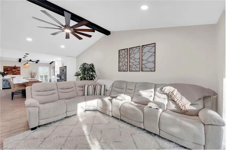 Living room featuring recessed lighting, wood finished floors, ceiling fan, and beverage cooler
