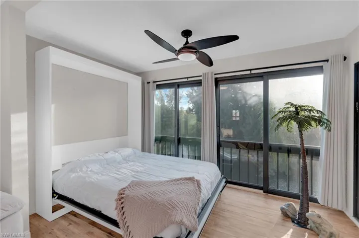 Bedroom with light wood-type flooring, access to outside, and a ceiling fan