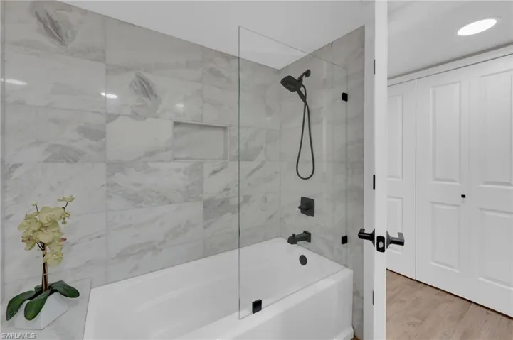 Bathroom featuring shower / washtub combination and wood finished floors