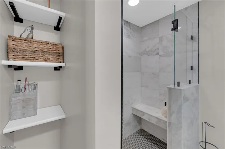 Full bathroom with a marble finish shower