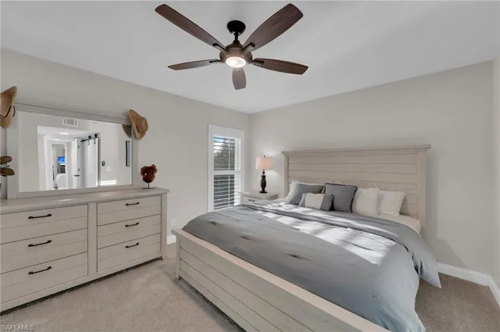 Bedroom with light colored carpet and ceiling fan