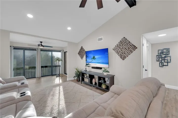 Living room featuring ceiling fan, lofted ceiling, recessed lighting, and wood finished floors
