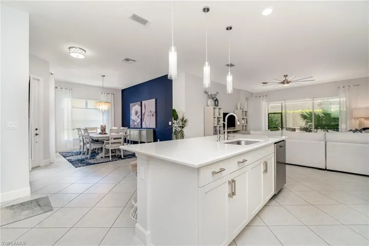 Kitchen island with open floor plan, pendant lights, and quartz countertops.