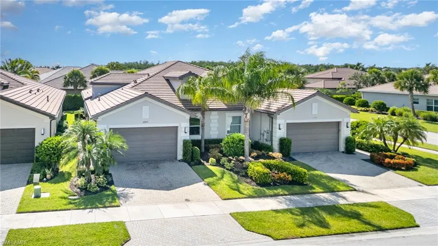 Villa home featuring a residential view, decorative driveway, stucco siding, and a tile roof.