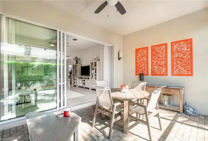 Large screened-in lanai featuring 3-door slider, ceiling fan, and entertaining space.