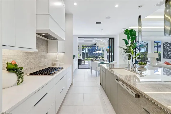 Kitchen featuring modern cabinets, pendant lighting, white cabinetry, decorative backsplash, and recessed lighting