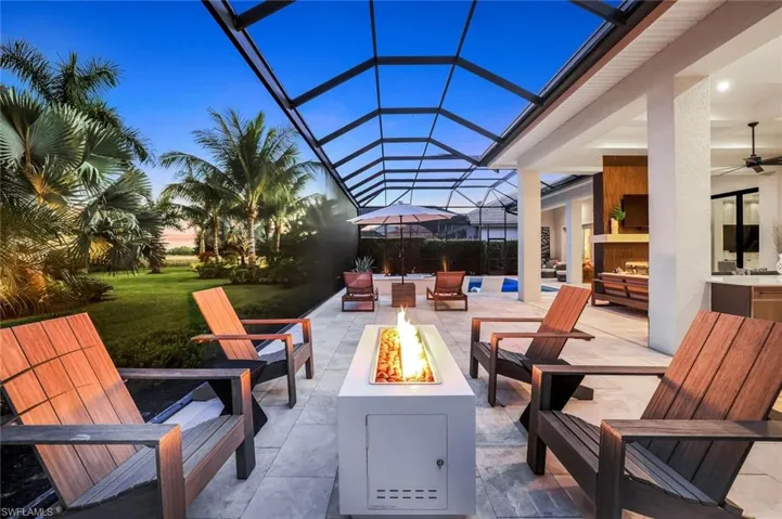 Patio terrace at dusk featuring a patio, a ceiling fan, a sunroom, and glass enclosure