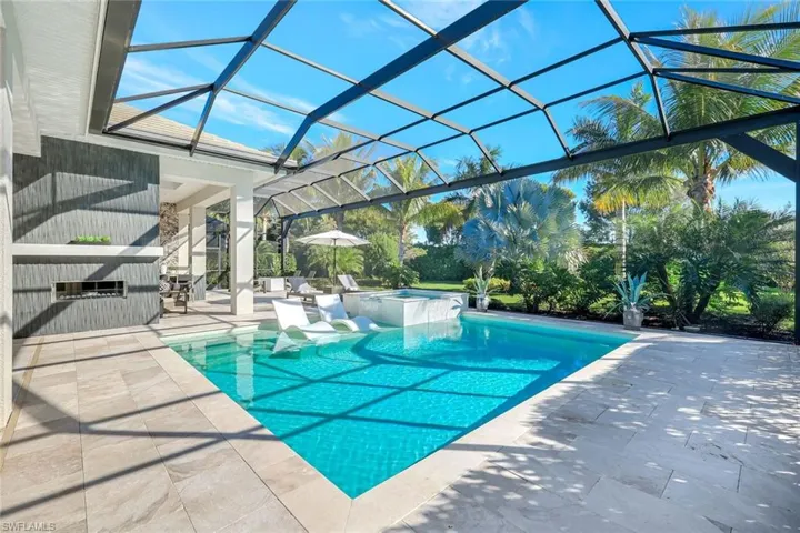 View of swimming pool with a sunroom, a patio, glass enclosure, and a pool with connected hot tub