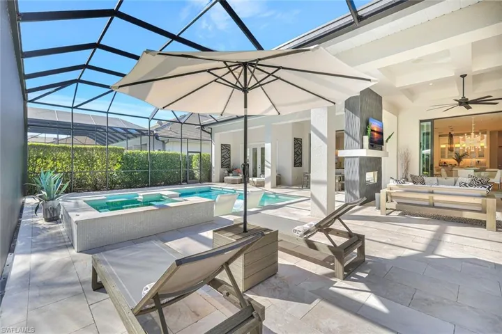 View of swimming pool featuring glass enclosure, a patio, a sunroom, and outdoor lounge area