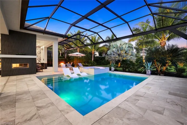 View of pool with a sunroom, a patio, a pool with connected hot tub, and glass enclosure
