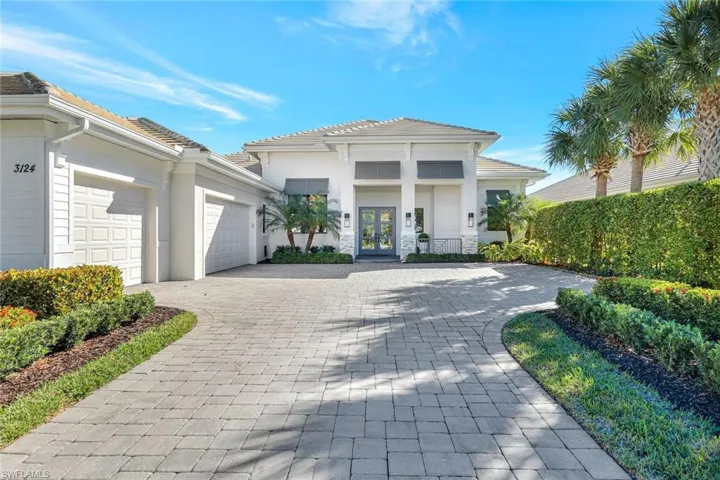 View of front of home featuring decorative driveway, french doors, a garage, and stucco siding