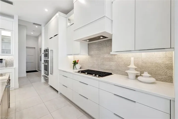 Kitchen featuring glass insert cabinets, modern cabinets, white cabinets, and recessed lighting