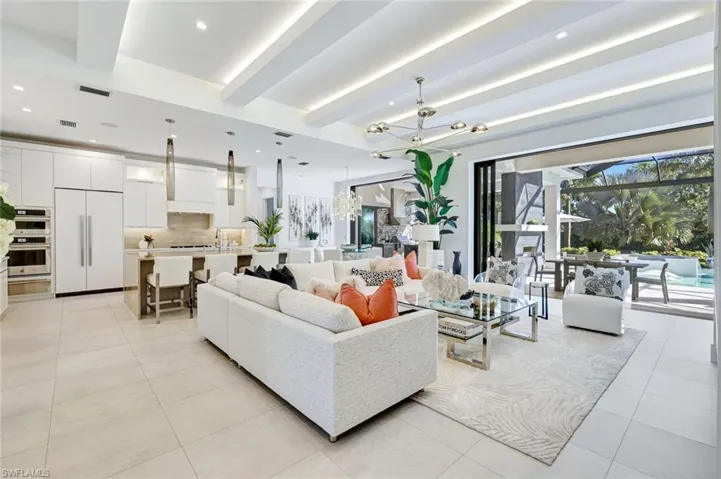Living area with a chandelier, beam ceiling, recessed lighting, and light tile patterned floors