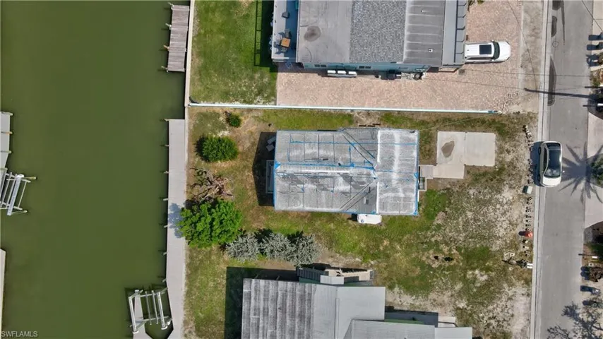 Bird's eye view of property with dock. The home next door is also for sale.