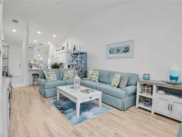 Living room with light hardwood / wood-style floors and lofted ceiling