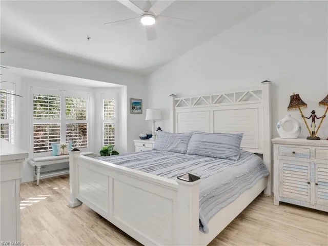 Bedroom with ceiling fan, vaulted ceiling, and light wood-type flooring