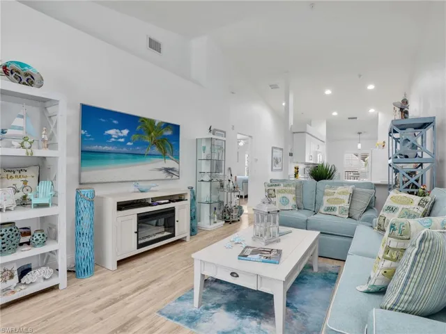 Living room with vaulted ceiling and light wood-type flooring