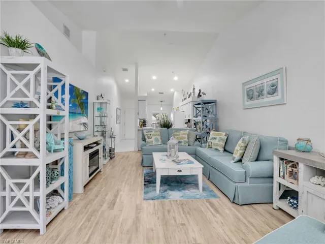 Living room featuring high vaulted ceiling and light wood-type flooring