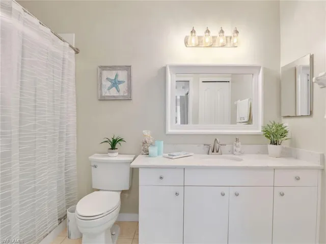 Bathroom with toilet, vanity, and tile patterned flooring