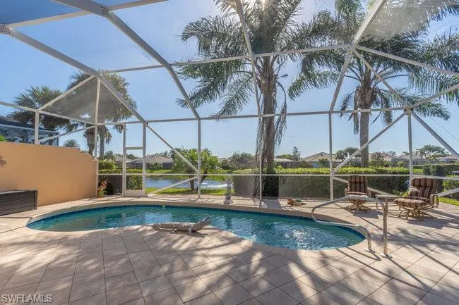 View of swimming pool with a water view, a patio area, and a lanai