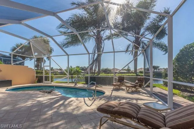 View of swimming pool with a lanai, a patio, and a water view