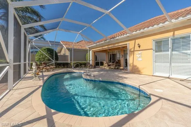 View of swimming pool with a lanai and a patio area