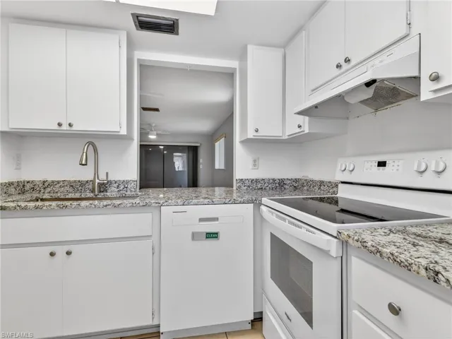 Kitchen featuring white cabinetry and granite countertops