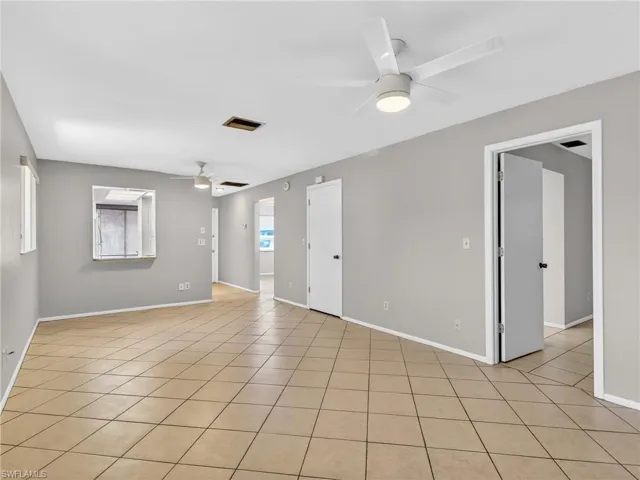 Spacious interior with tile flooring throughout, featuring light gray walls and white trim