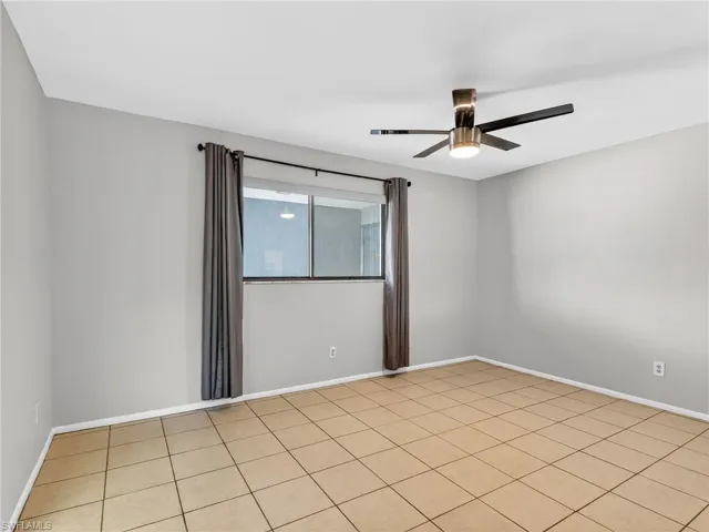 Spacious room featuring neutral-toned tile flooring and light gray painted walls