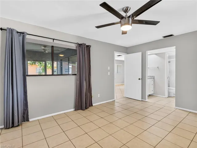 Spacious room featuring tile flooring, a contemporary ceiling fan with integrated lighting, and a large window