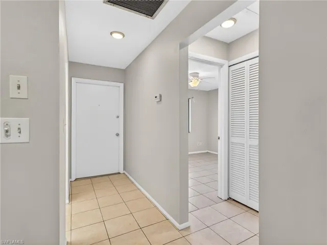 Entry foyer with light beige tile flooring and neutral wall tones