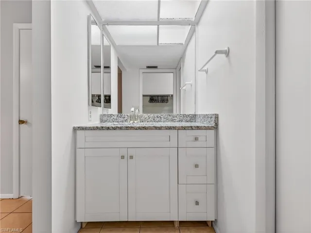 Bathroom vanity featuring a speckled countertop, integrated sink, and dual-door cabinetry