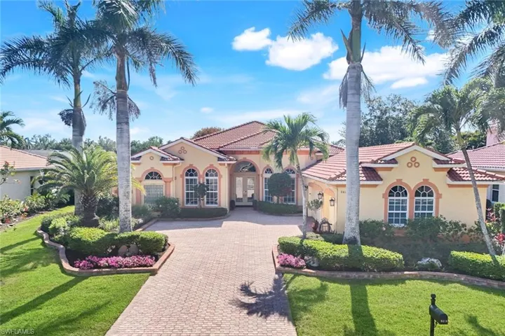 View of front of house featuring decorative driveway, stucco siding, and a front lawn