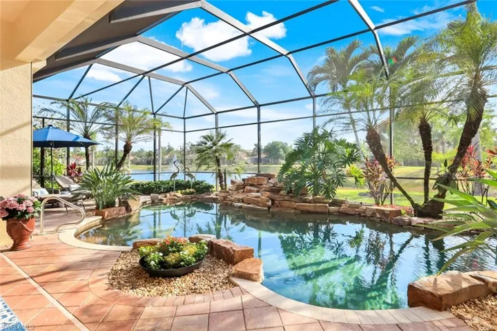 Swimming pool with glass enclosure, a sunroom, and a patio area