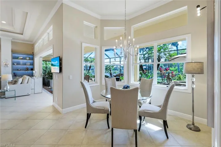 Dining area with ornamental molding, light tile patterned floors, and a chandelier