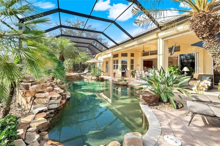 Swimming pool with a sunroom, a lanai, a patio, and grilling area