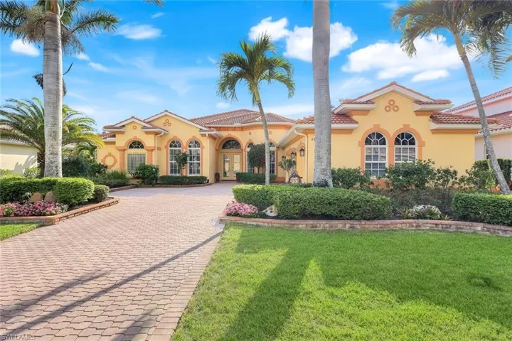 Mediterranean / spanish-style home featuring decorative driveway, stucco siding, a front yard, and a tile roof
