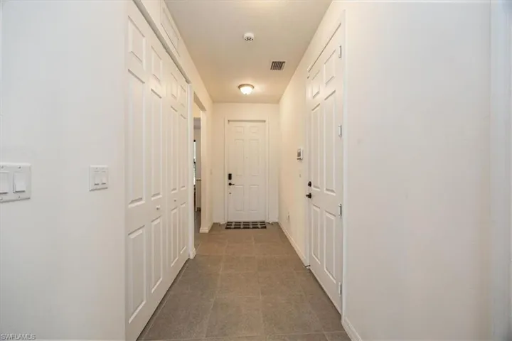 Hall with baseboards and visible vents