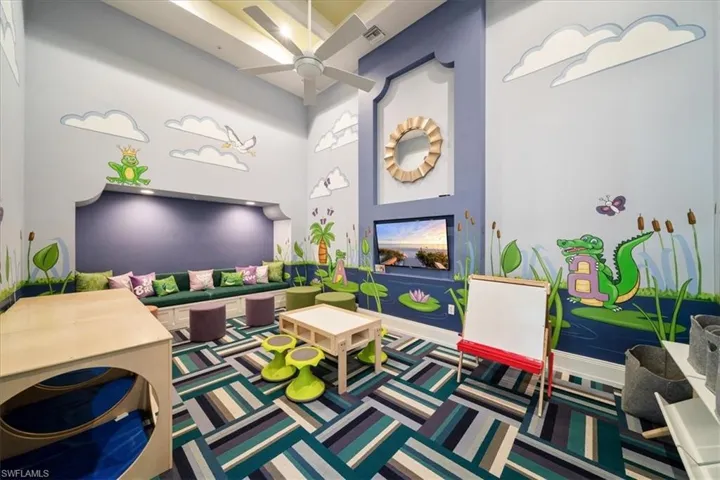 Game room with a towering ceiling, carpet, a ceiling fan, and visible vents