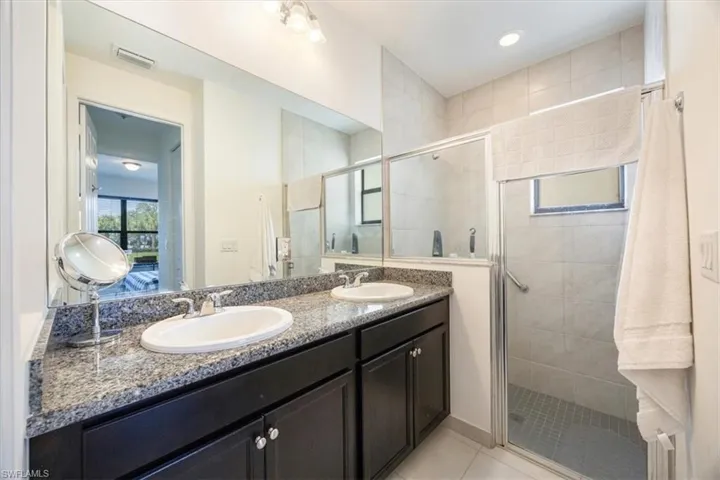 Full bath featuring visible vents, a shower stall, and a sink