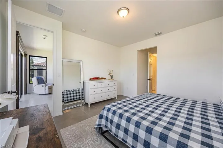 Tiled bedroom featuring visible vents