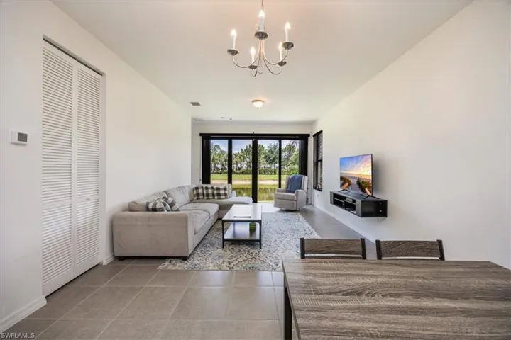 Living room featuring an inviting chandelier, baseboards, tile patterned floors, and visible vents