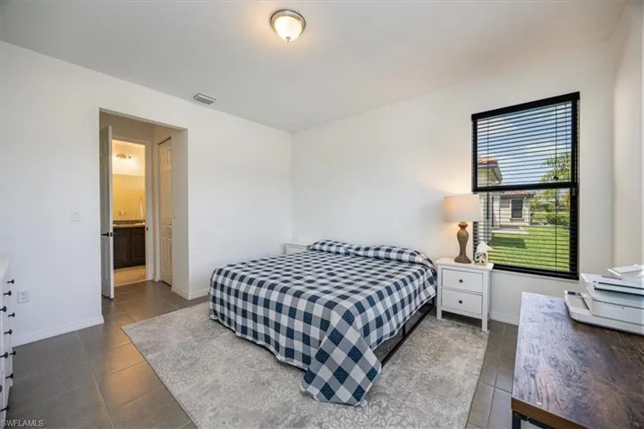 Bedroom featuring dark tile patterned flooring and baseboards