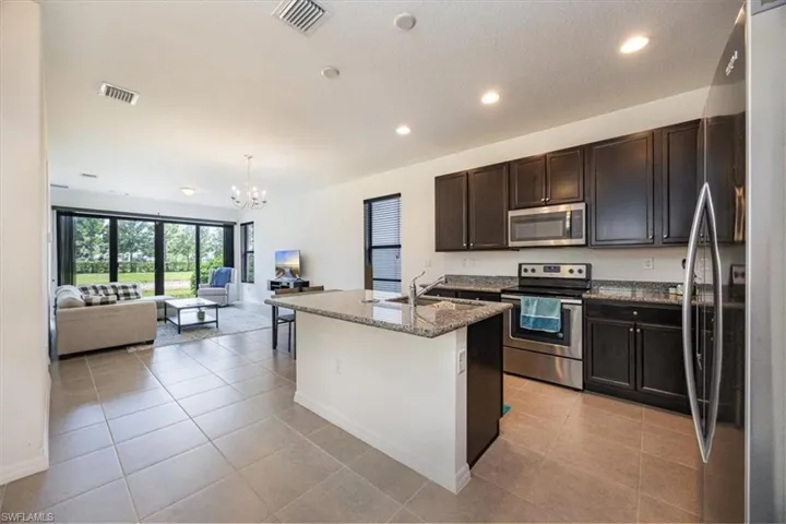 Kitchen featuring a sink, a notable chandelier, stainless steel appliances, and visible vents