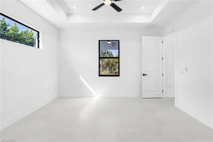 Spare room featuring a tray ceiling, ceiling fan, and recessed lighting