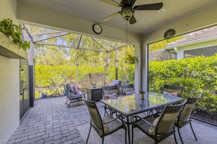 View of patio / terrace with a lanai, a sunroom, outdoor dining space, and ceiling fan