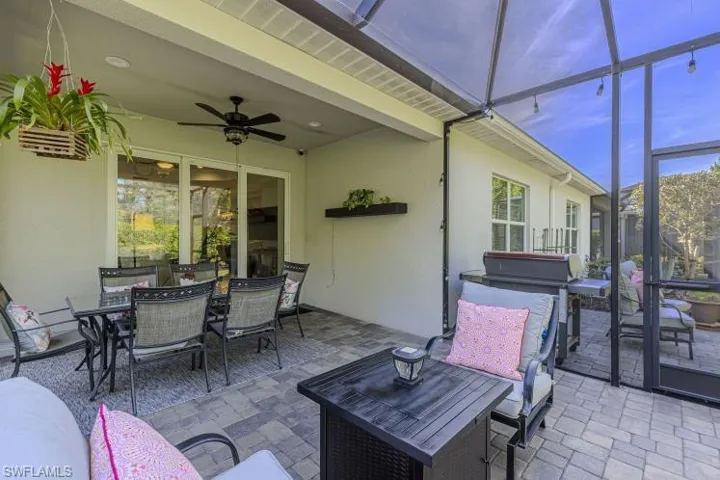 View of patio with outdoor dining space, a lanai, a sunroom, and ceiling fan