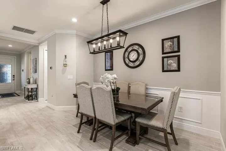 Dining room featuring crown molding, light wood-style flooring, and recessed lighting